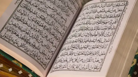 Close Up Of Open Copy Of The Quran On Stand At Home