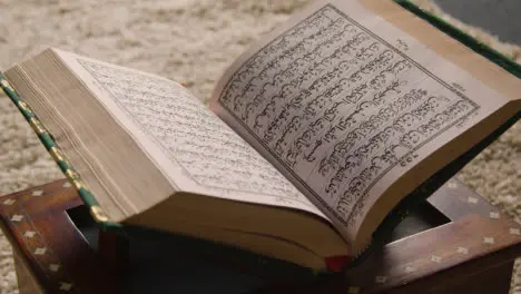 Close Up Of Open Copy Of The Quran On Stand At Home 2