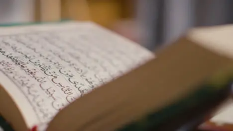 Close Up Of Open Copy Of The Quran On Stand At Home 8