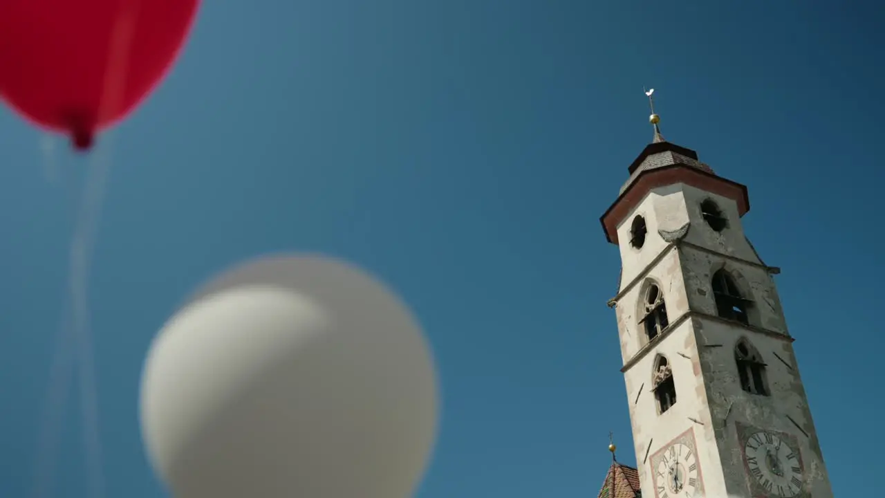 Church tower with heart shaped balloons wedding day