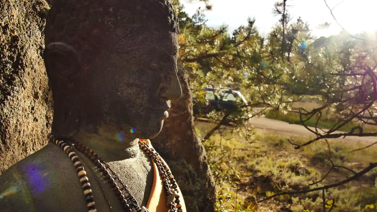 Lens flare across a stone Buddha's face at the stupa in Red Feather Lakes CO