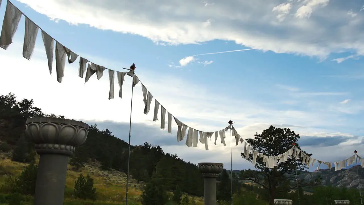 White prayer flags blowing in the breeze as the sun goes down at the stupa in Red Feather Lakes CO