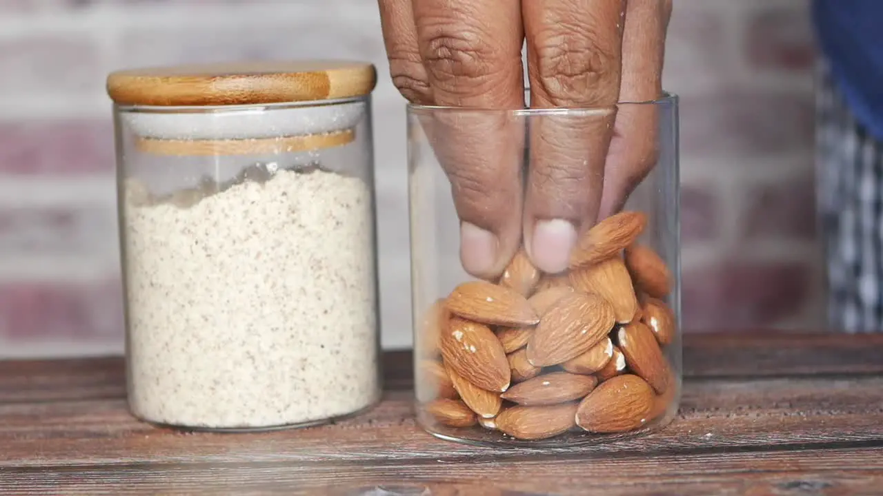 Almond powder and almond in a jar on table