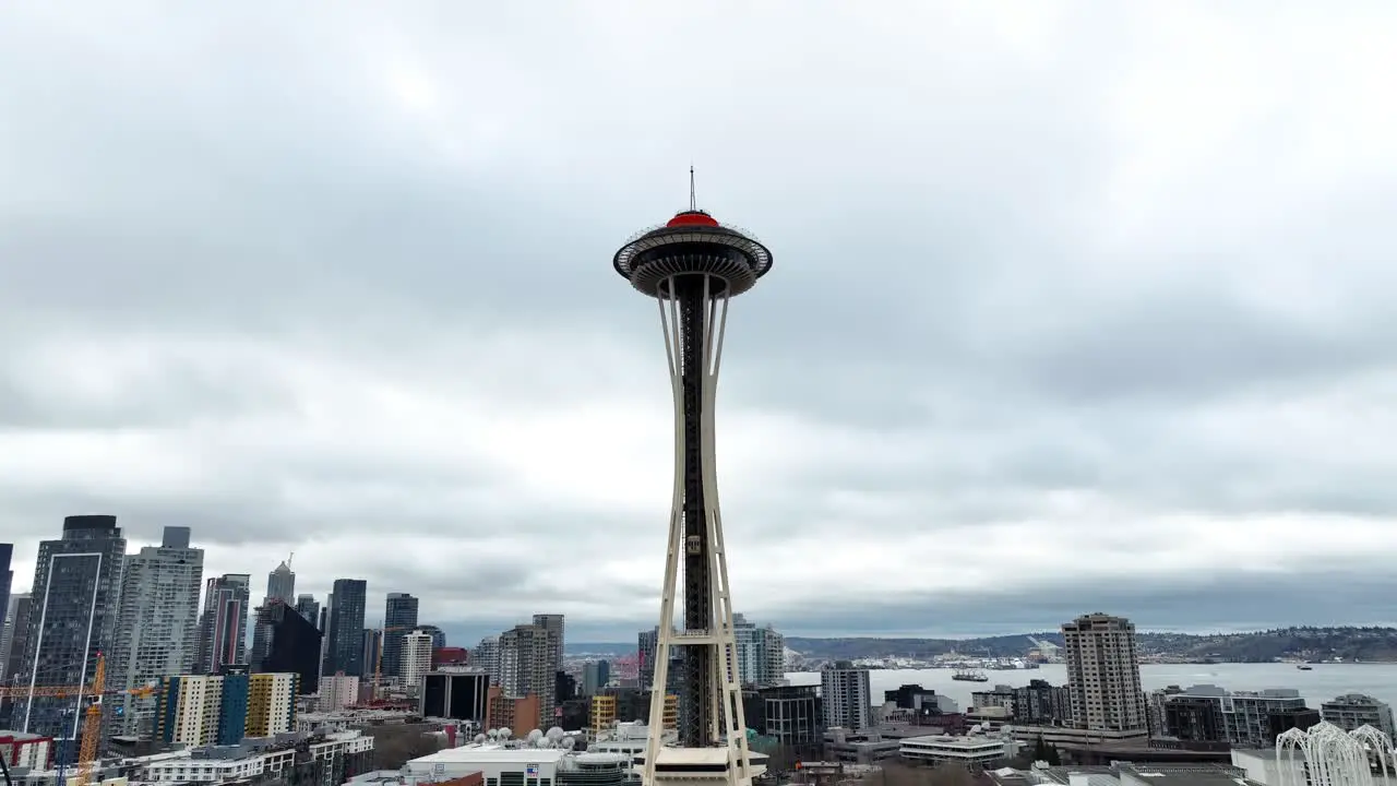 Aerial orbit of Space Needle overlooking the city of Seattle Washington on a cloudy day