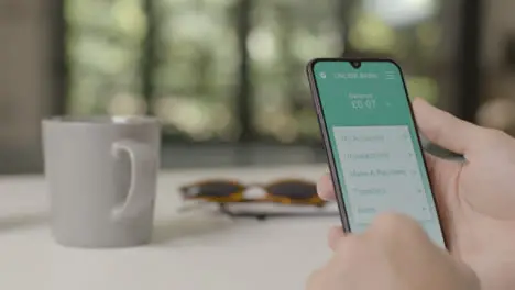 Sliding Shot Approaching a Hand Holding a Smartphone On a Mobile Banking App