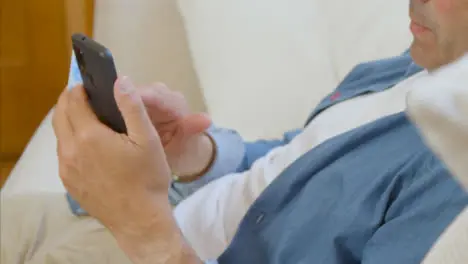 High Angle Shot of Middle Aged Man Scrolling On His Smartphone