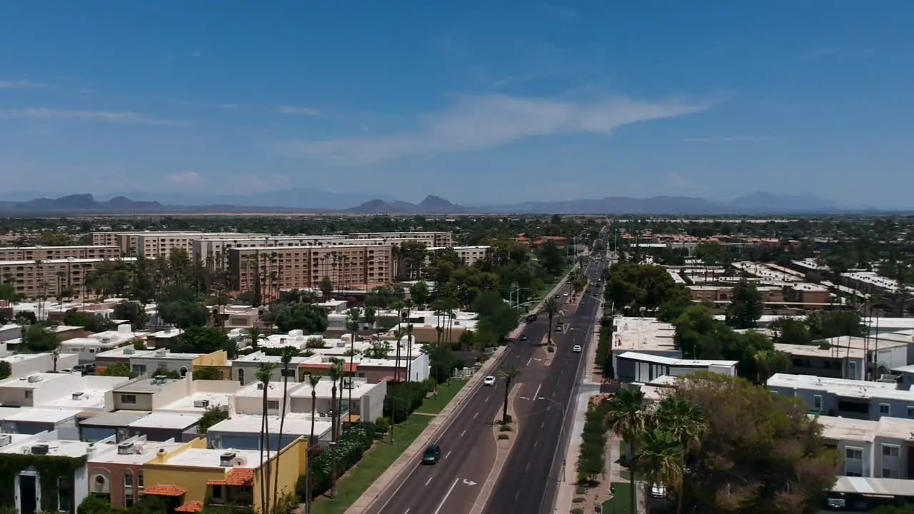 Drone footage over residential area and busy road in Scottsdale Arizona with Camelback Mountain in the background