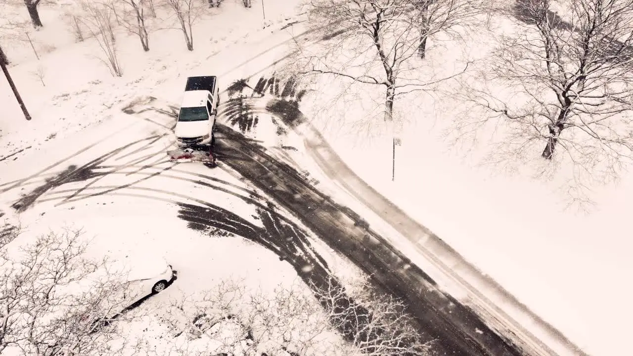 White pickup truck plowing local streets in Toronto aerial view during snowfall