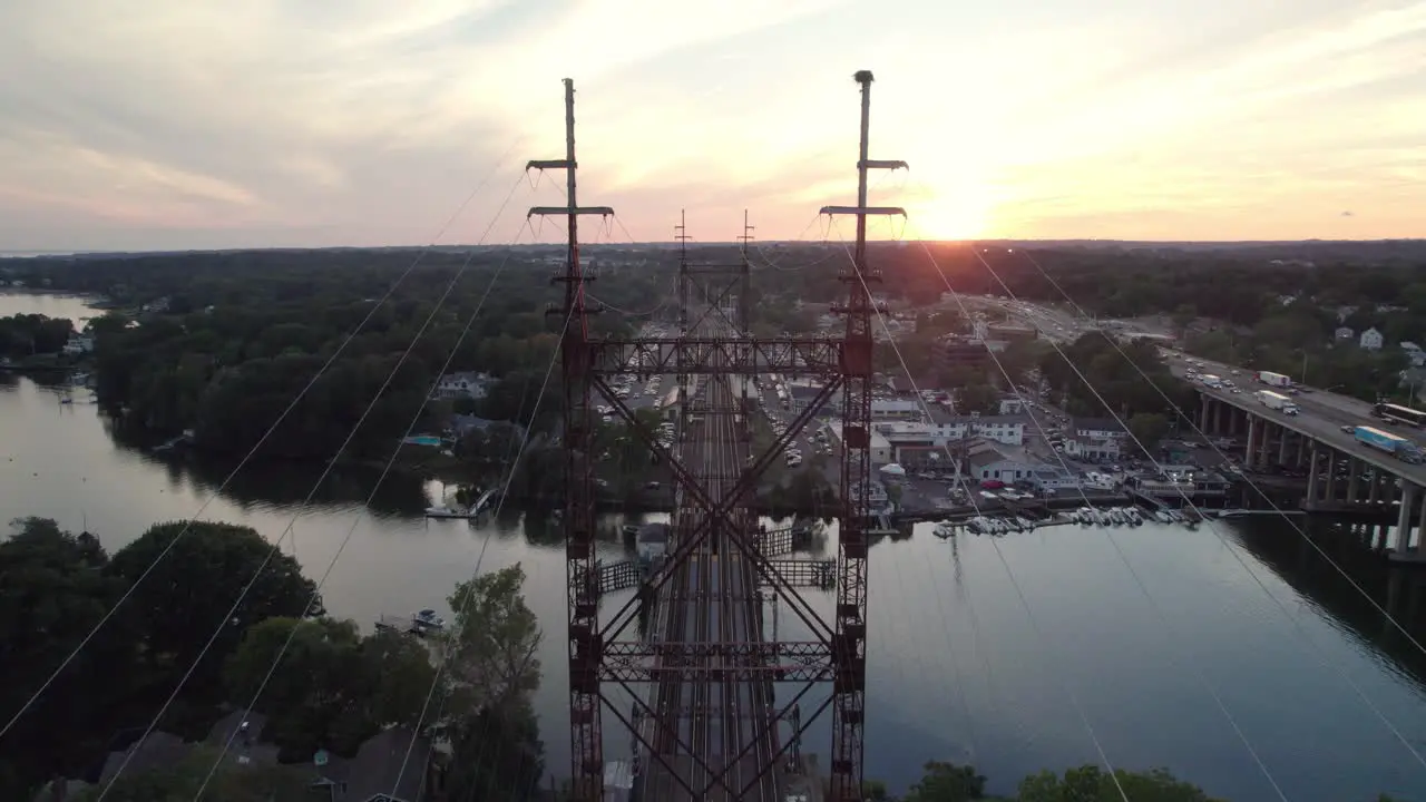 Drone Shot Moving Forward Over Train Tracks with Wires Sunset and Interstate in the Background