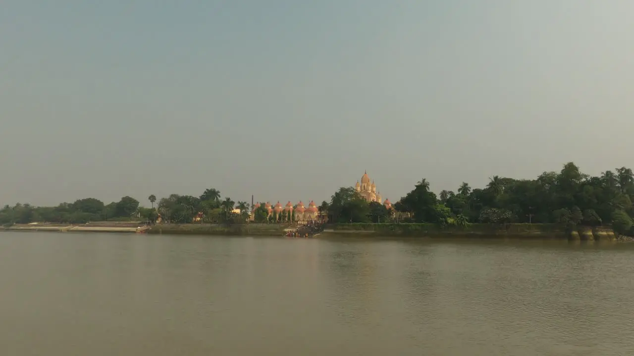 The Dakshineswar Kali Temple is seen from the jetty ghat or ferry boat with the Hooghly River in the foreground