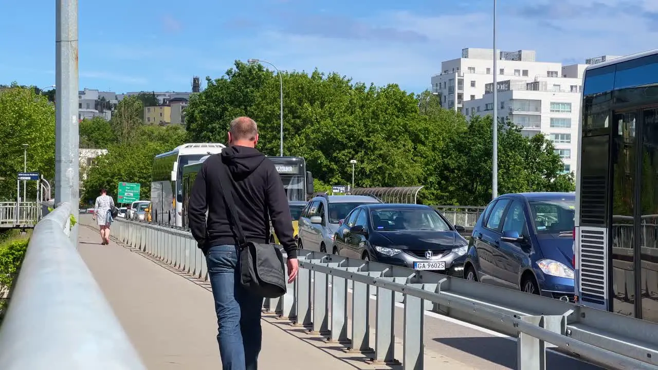 Man with black bag walks along pavement along scrambled street Gdynia Redłowo