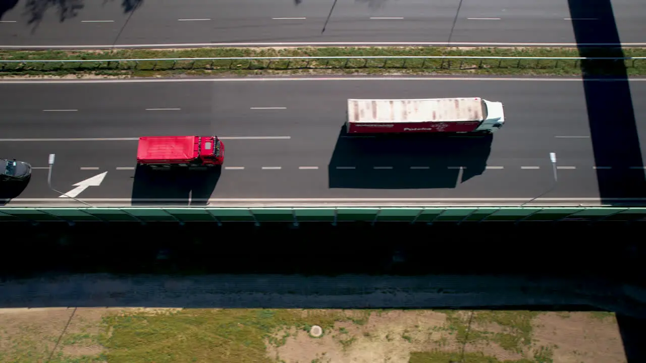 Aerial top down tracking truck moving on expressways multi-lane connections of agglomerations modern and safe roads maintaining supply chain and logistics