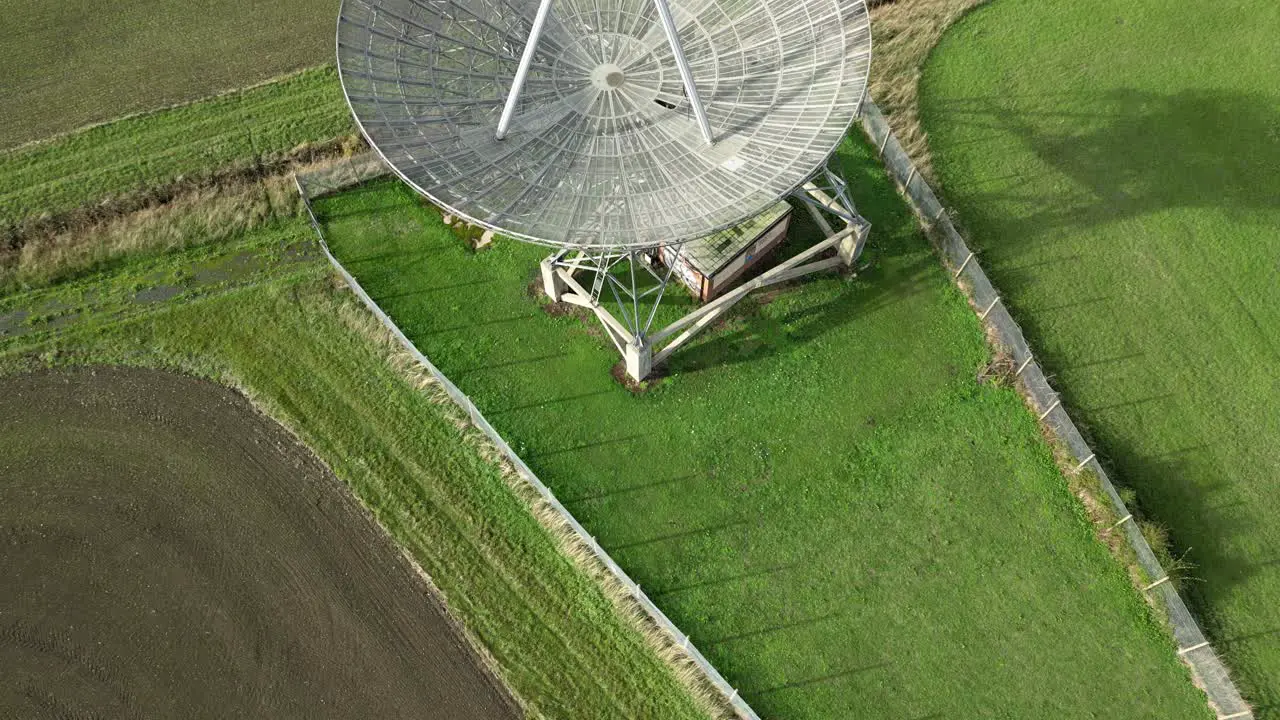 Aerial revealing shot of the modern radiotelescope antenna at the Mullard Radio Astronomy Observatory