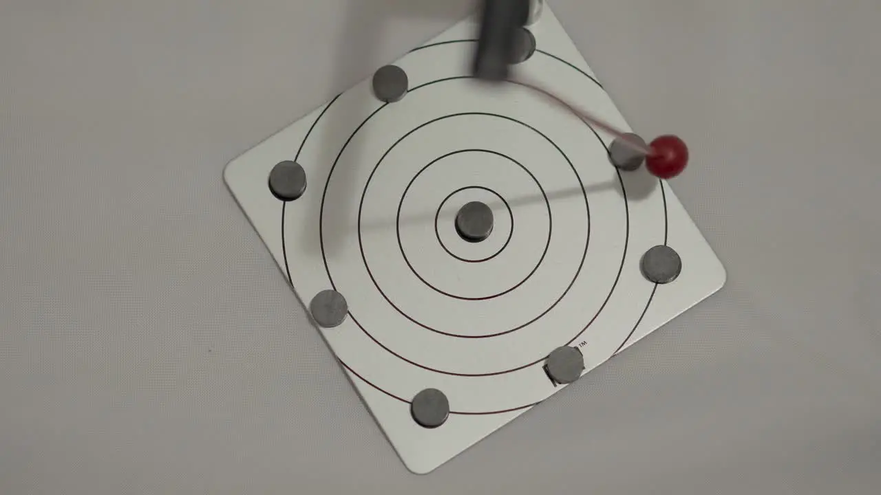 Overhead Shot of Randomly Oscillating Magnetic Pendulum in Motion