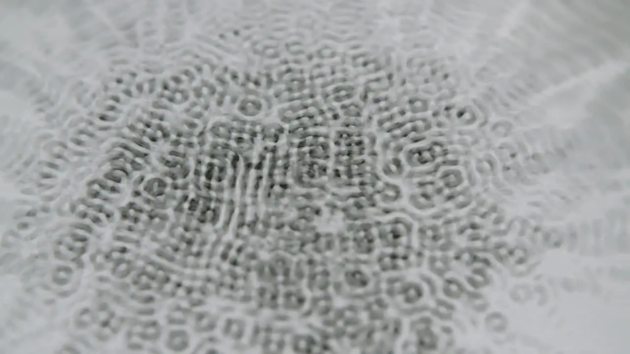 Water forming micro cymatic patterns and reflecting light