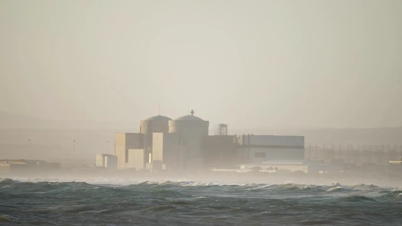 Koeberg nuclear power station on the edge of a stormy ocean surrounded by mist