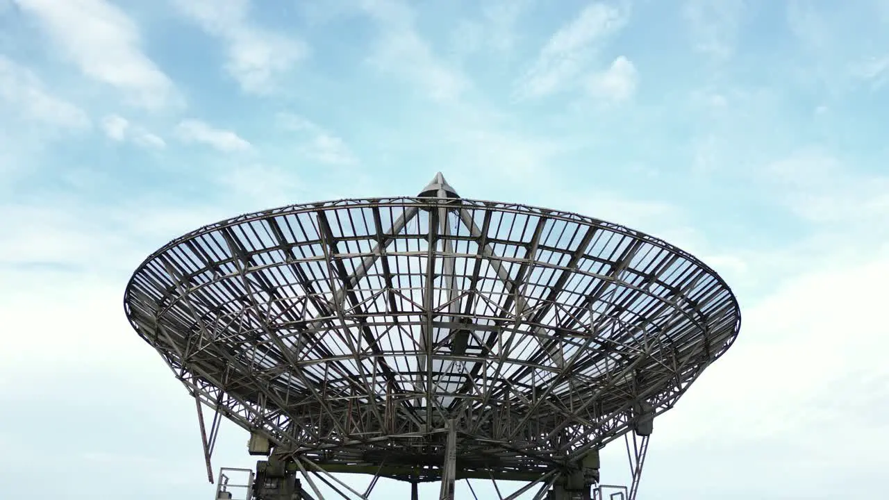 Aerial close descent shot of the modern radiotelescope antenna at the Mullard Radio Astronomy Observatory