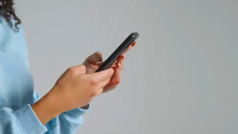 Tracking Shot of Young Adult Womans Hands Using Smartphone