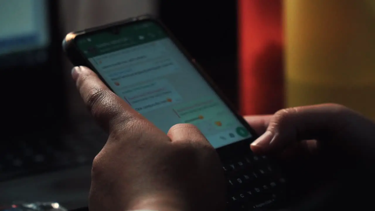 Close up shot of person typing message with finger on smartphone screen in WhatsApp