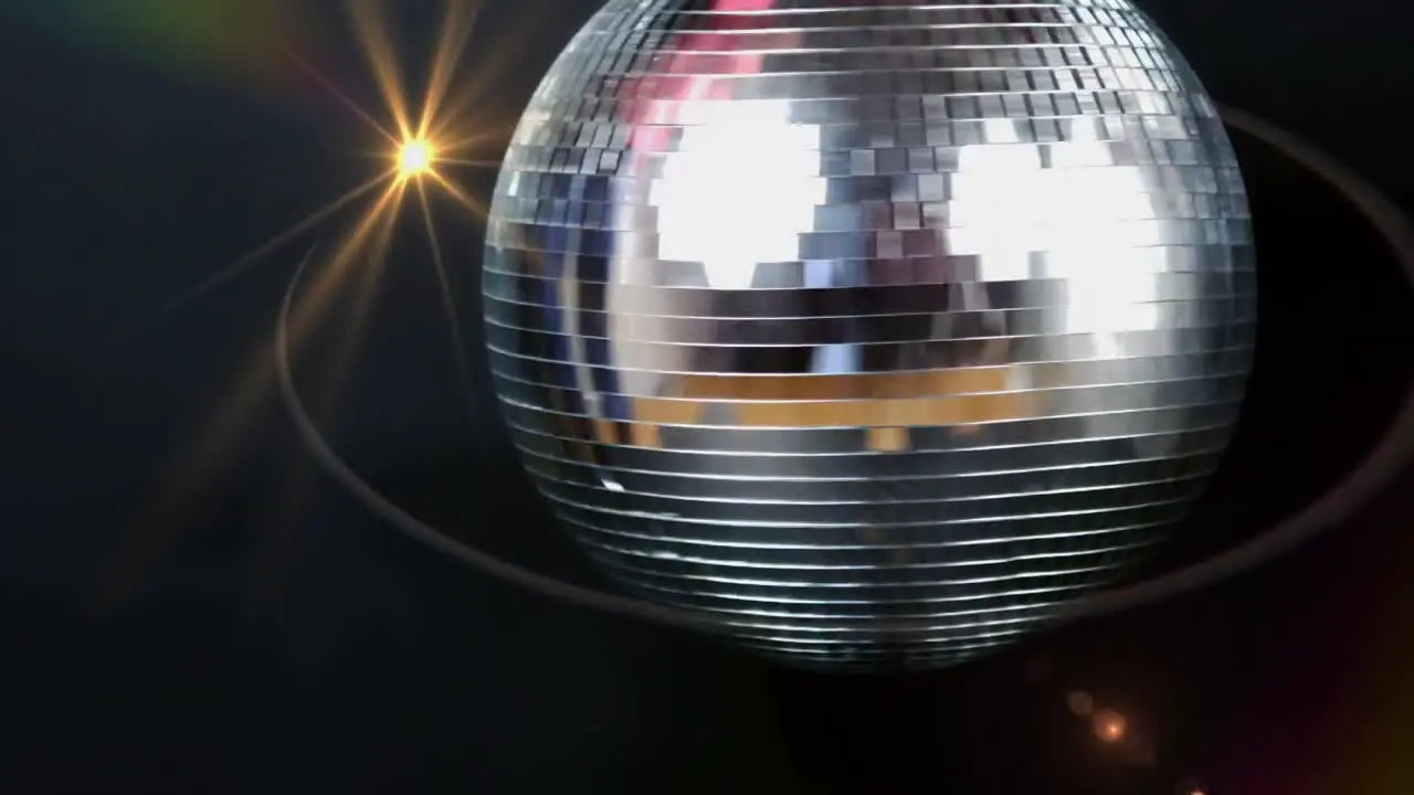 Animation of yellow light moving over spinning disco mirror ball