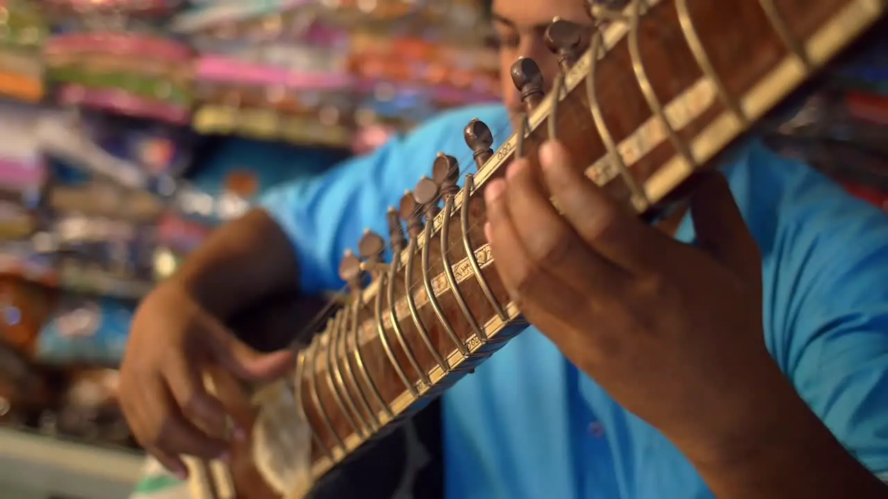 Close Up Panning Shot of a Man Playing a Sitar