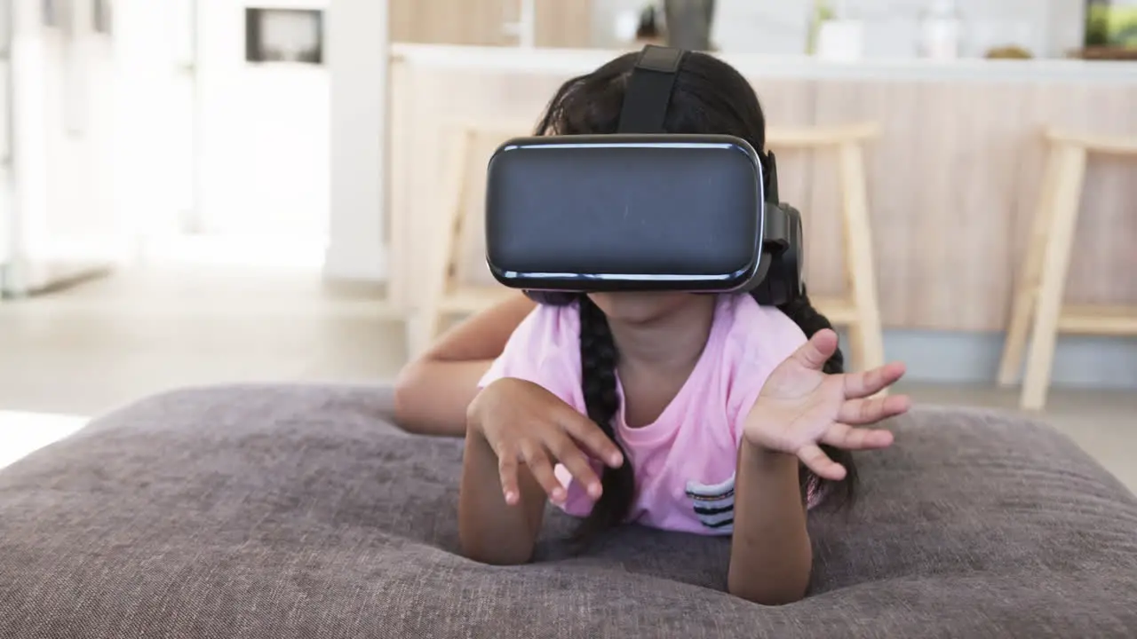 Biracial girl with a VR headset experiences virtual reality hands raised defensively