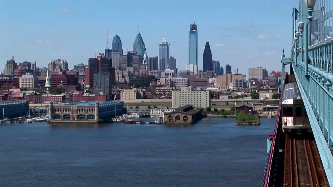 A rapid transit train drives across Ben Franklin Bridge away from Philadelphia Pennsylvania 