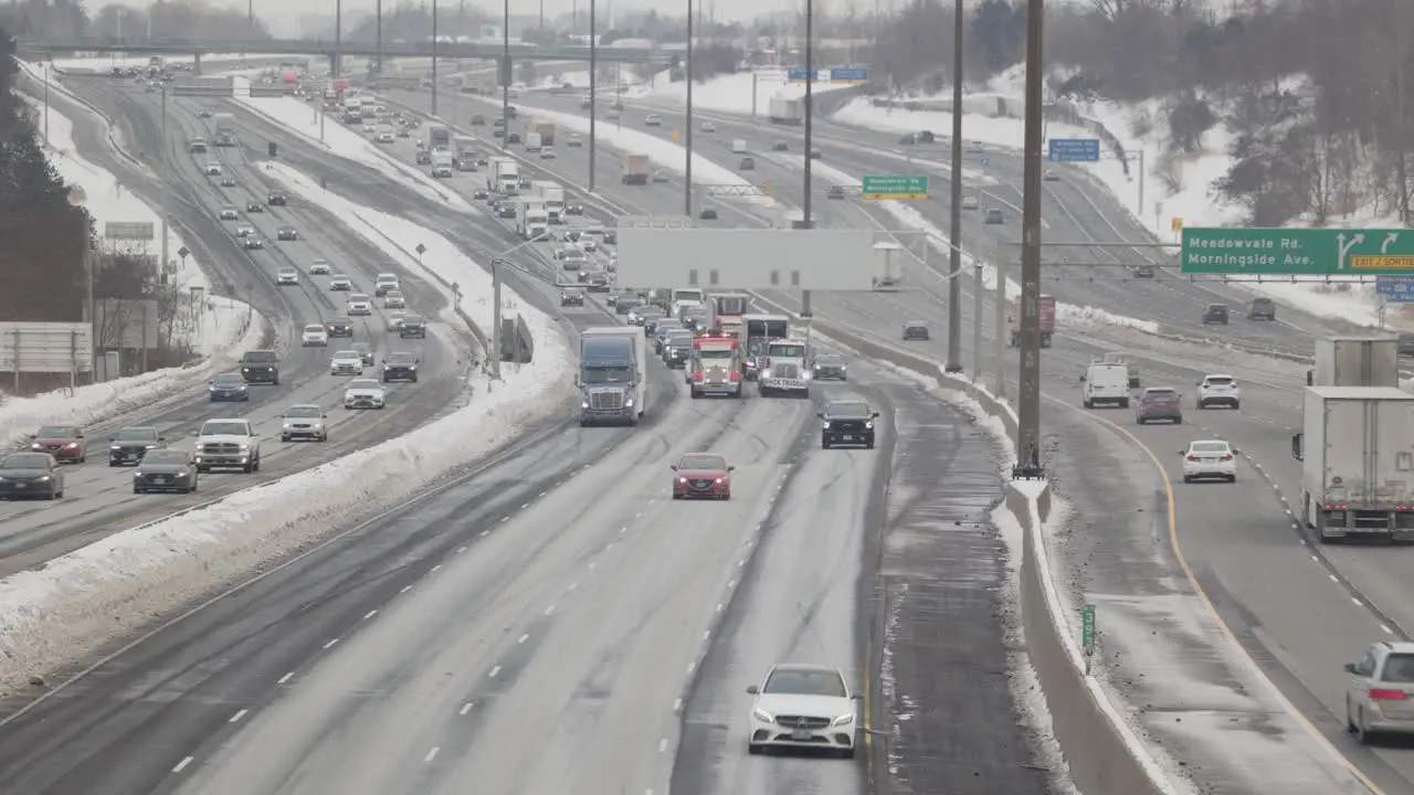 Large Convoy of Transport Trucks heading East on 5-lane highway creating traffic congestion