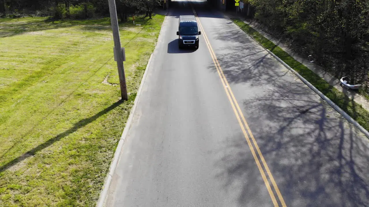 Amazon delivery van drives down city road aerial drone