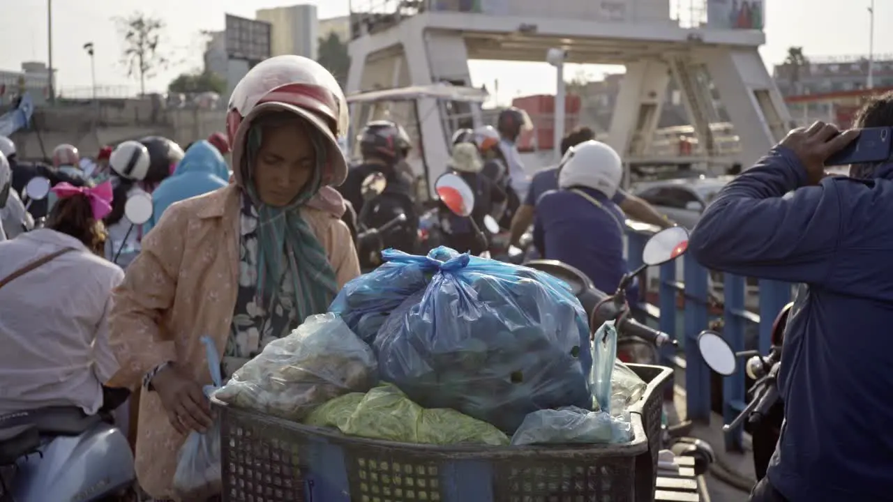 Woman transporting vegetables on fery boat