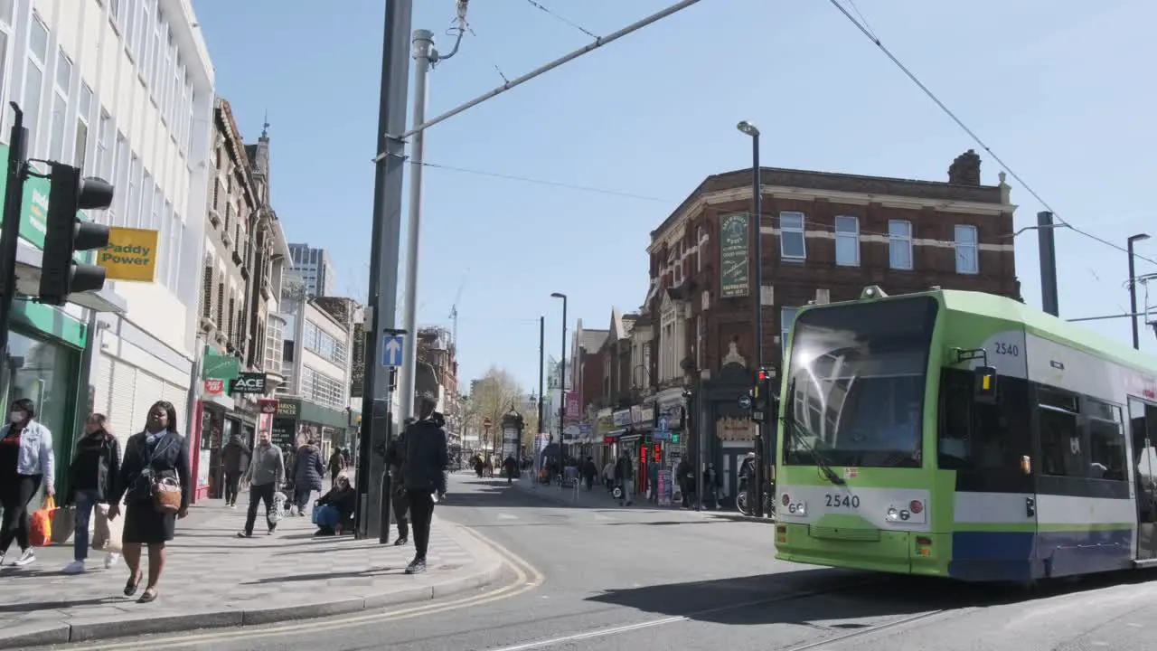 London tram passing through intersection in croydon old town follow