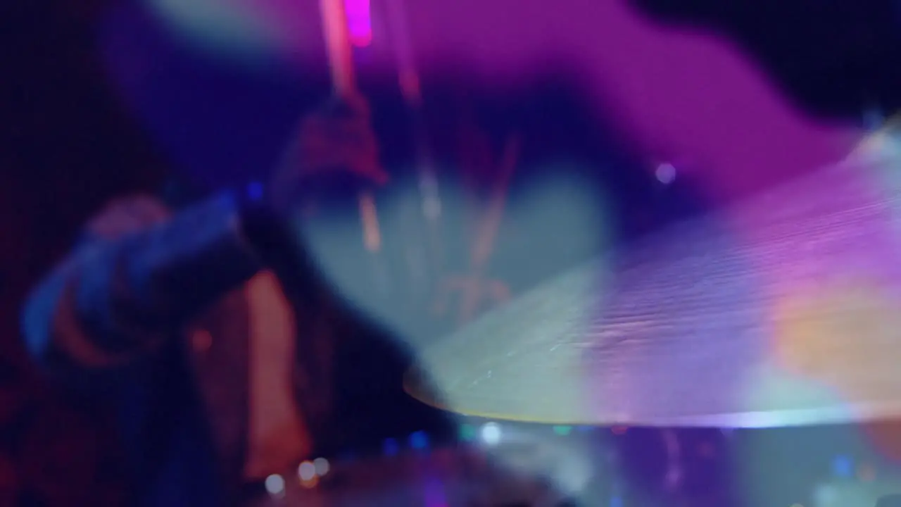 Animation of colourful light blurs over africna american man playing on drum kit in slow motion