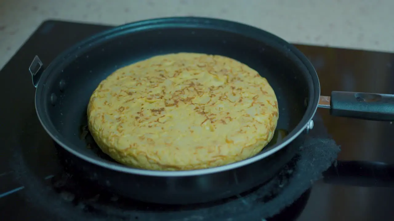 moving a potato omelette cooking in a pan