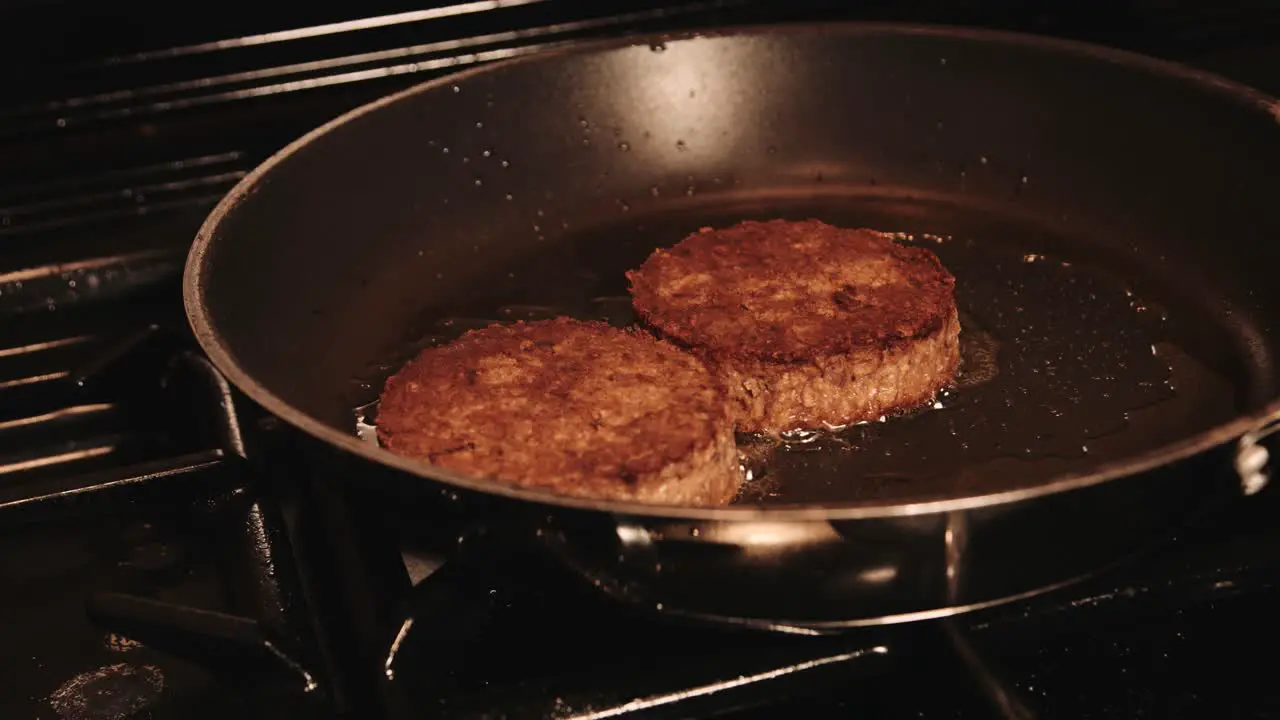 PlantBased Burgers Gently Frying in Pan with Oil on Gas Stove