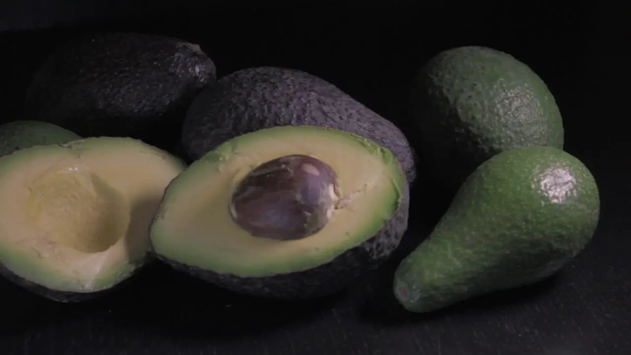 Avocadoes on black background