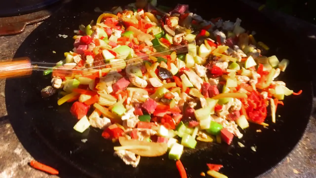 delicious colorful wok with bacon fried in a big pan food being cooked outside in the summer homemade outdoor kitchen