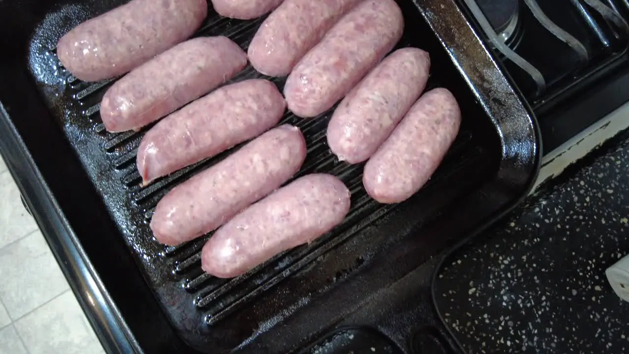 Grilling raw sausages on stove top in Mexico City Mexico wide shot top down