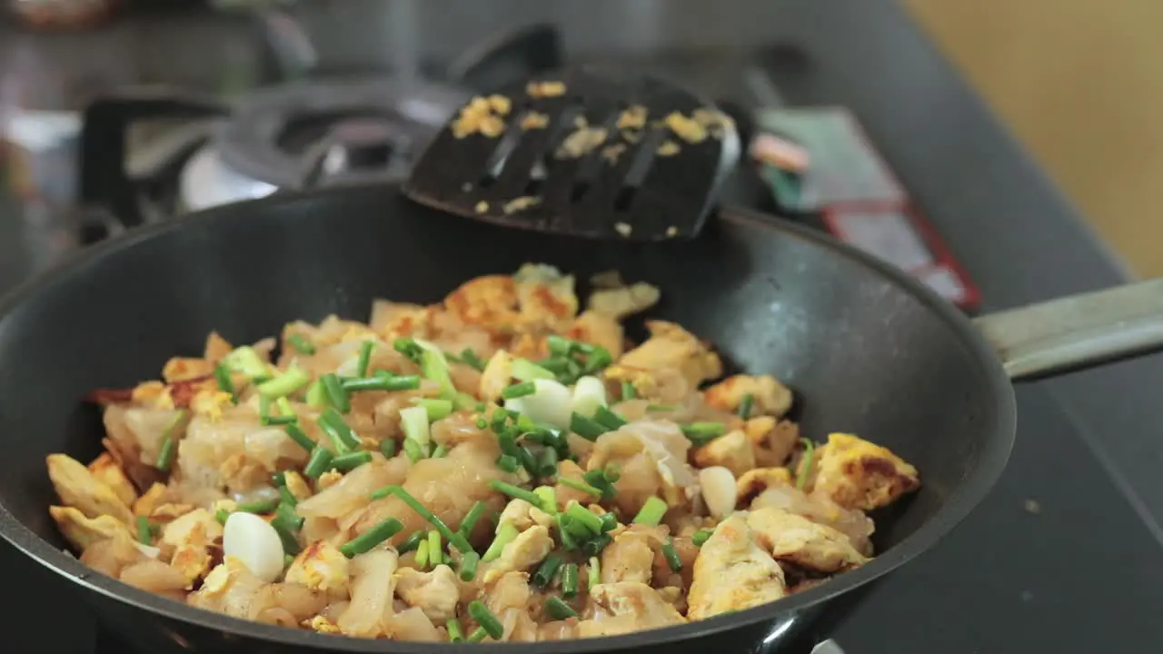 Adding fresh and diced spring onion to frying chicken with noodle menu thai recipe Thailand