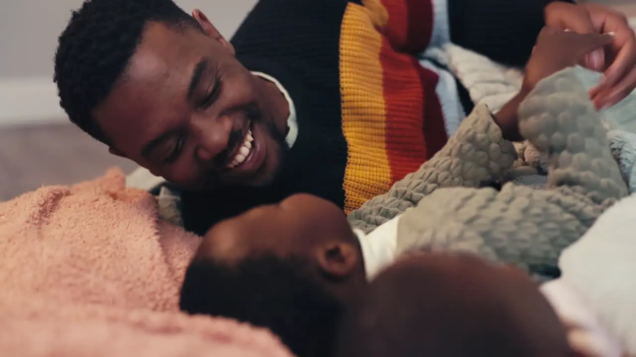 Black family playing and a father on the bed