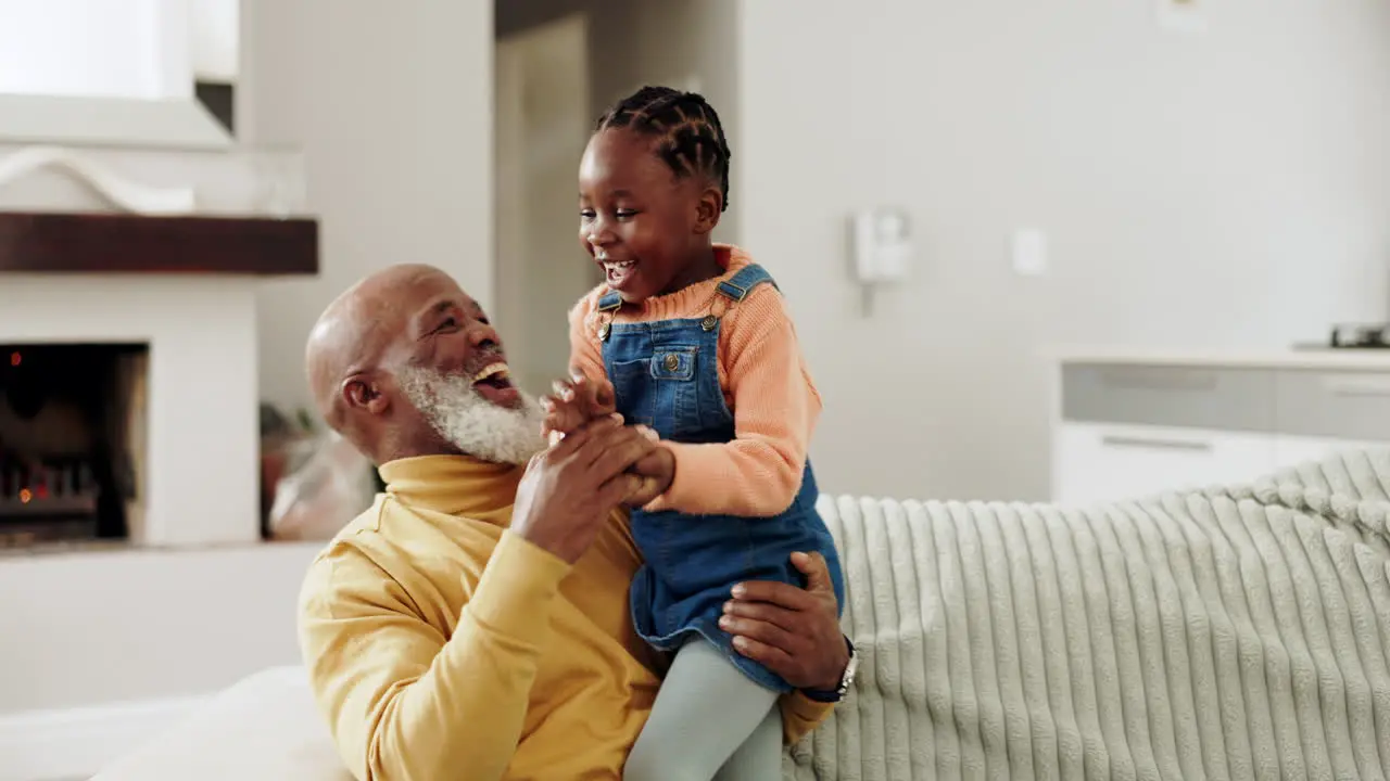 Playing grandfather and girl laugh on sofa