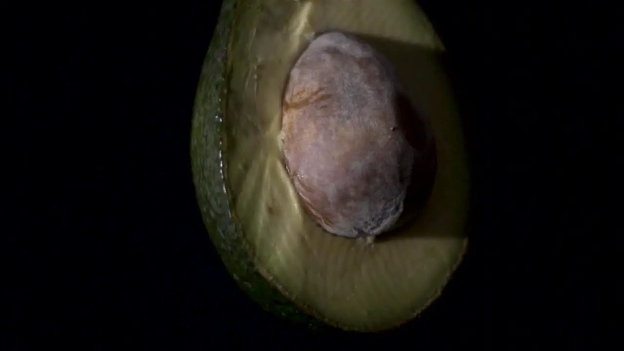 Close up shot of avocado spinning with a black background