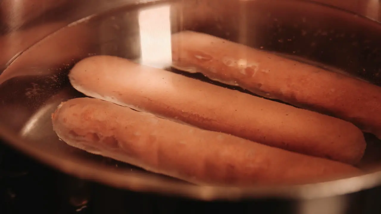 Vegan PlantBased HotDogs Being Cooked as Water Comes to the Boil