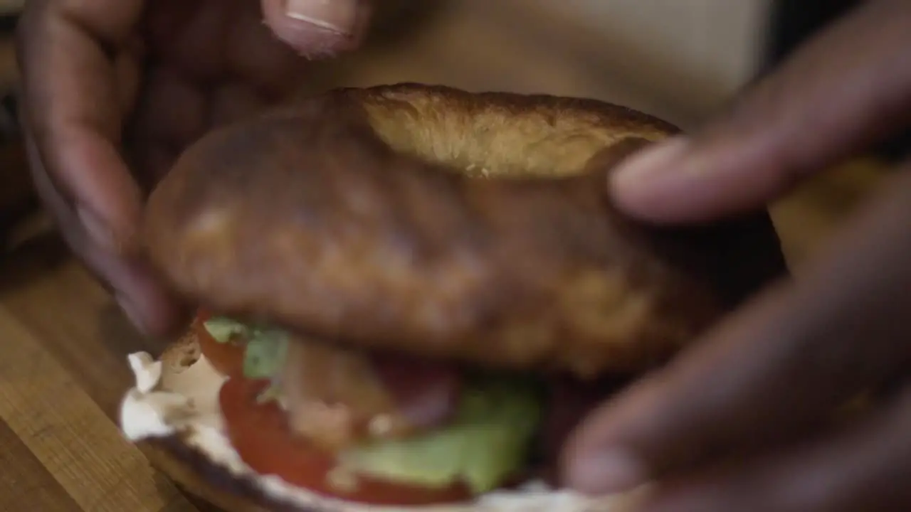 Close up shot squeezing a lemon onto a bacon Bagel