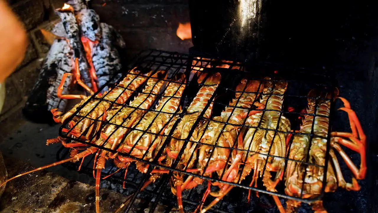 Crayfish on open fire being dressed with garlic-butter and barbecued on open fire