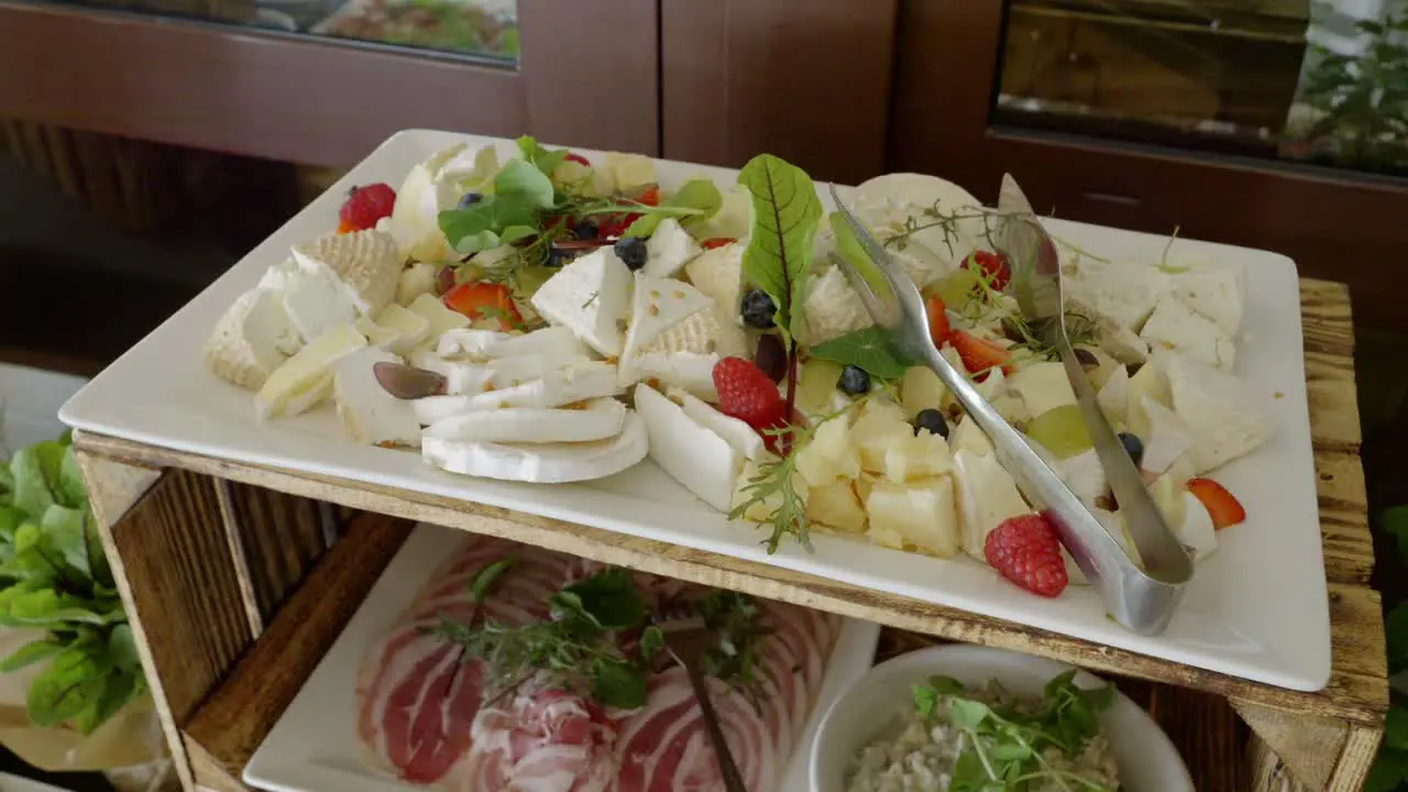 A rustic table made from a wooden crate on which there are cheeses and cold cuts