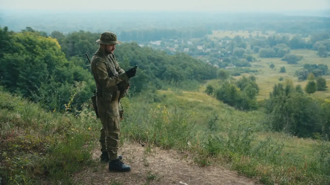 A man in camouflage looks at a compass 1