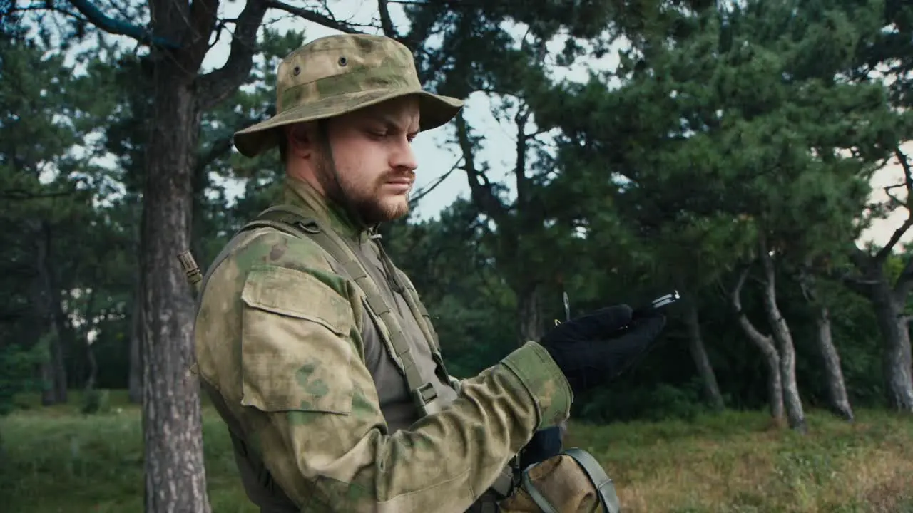 A man in camouflage looks at a compass 2