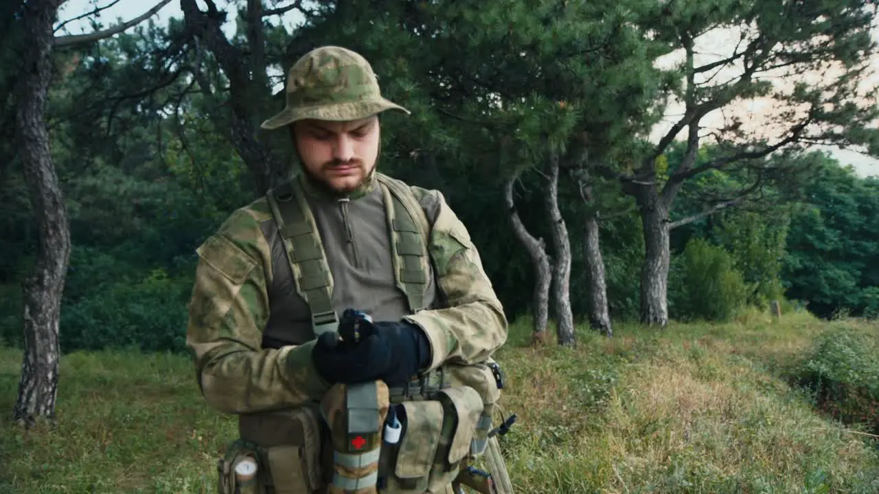 A man in camouflage looks at a compass