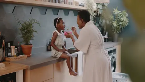 Black family home and mom feeding child