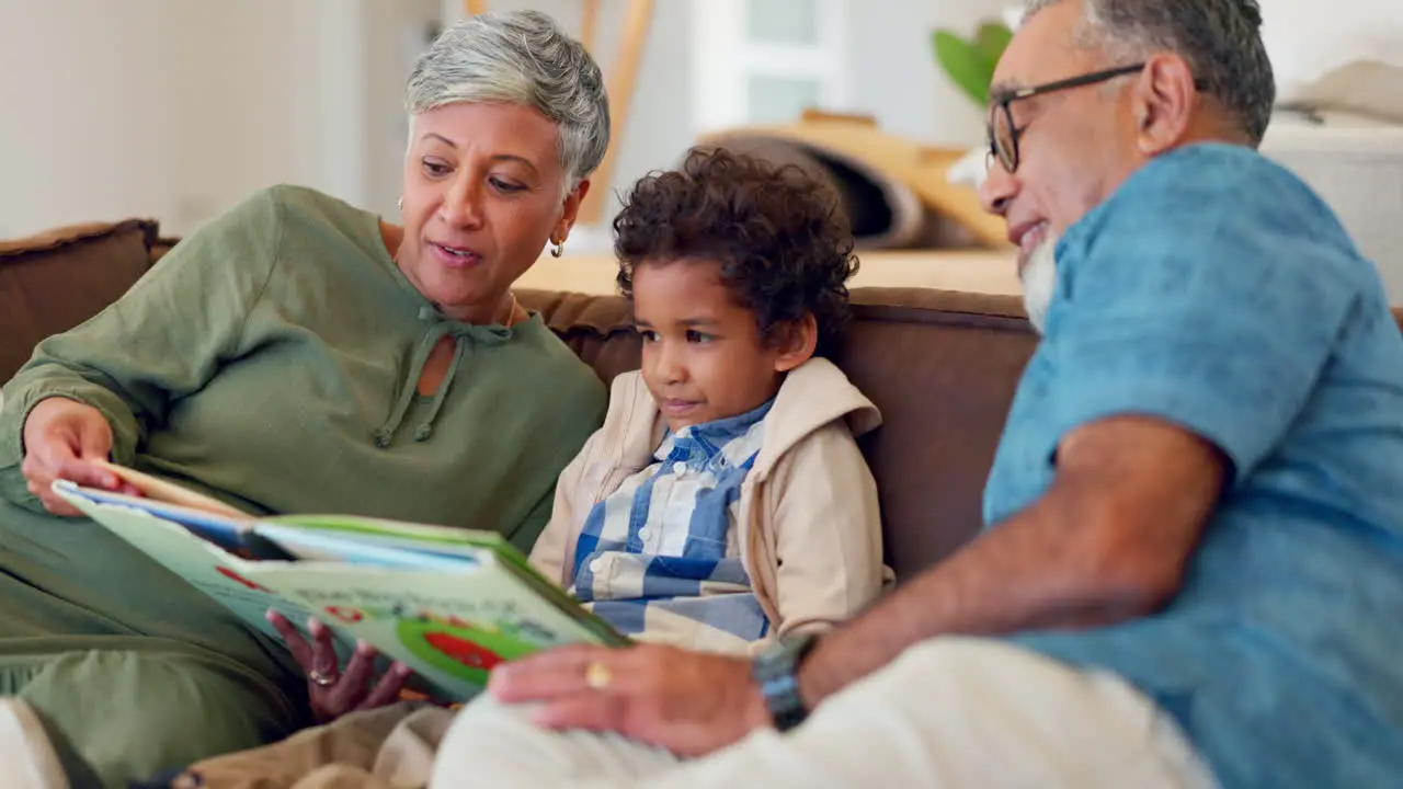 Grandparents child and reading books on sofa